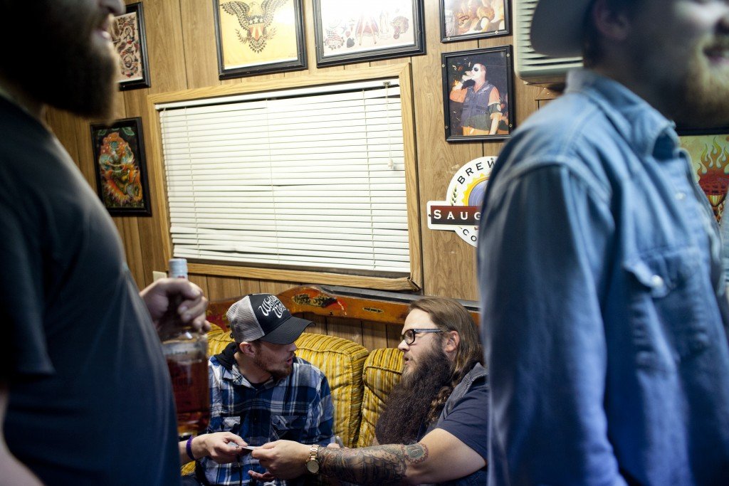 Flint native Whitey Morgan gives his latest CD to a fan during a VIP greeting session backstage before a show at The Machine Shop in Flint, MI on May 1, 2015.