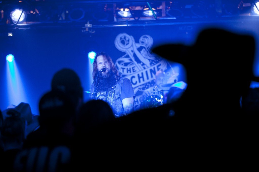 Flint native Whitey Morgan is bathed in blue stage light as he is seen through the audience members during a show at The Machine Shop in Flint, MI on May 1, 2015.